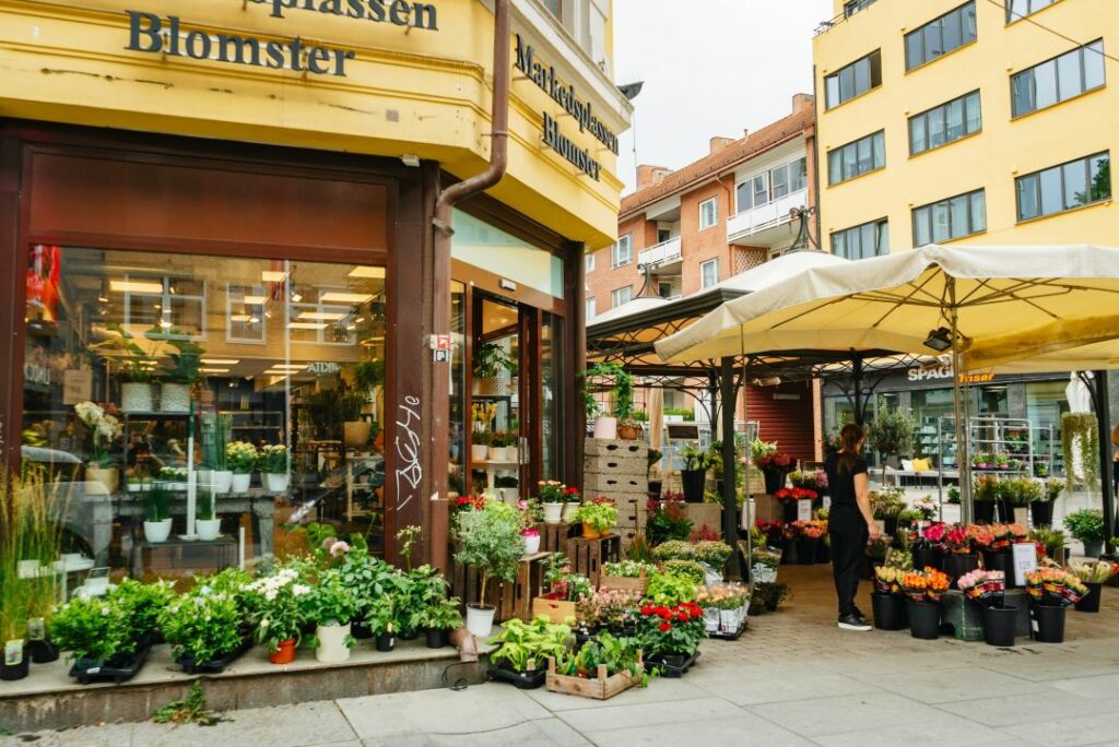 A flower shop in Majorstuen city district of Oslo on a summe day. Lots of plants and flowers displayed outside this corner shop. 