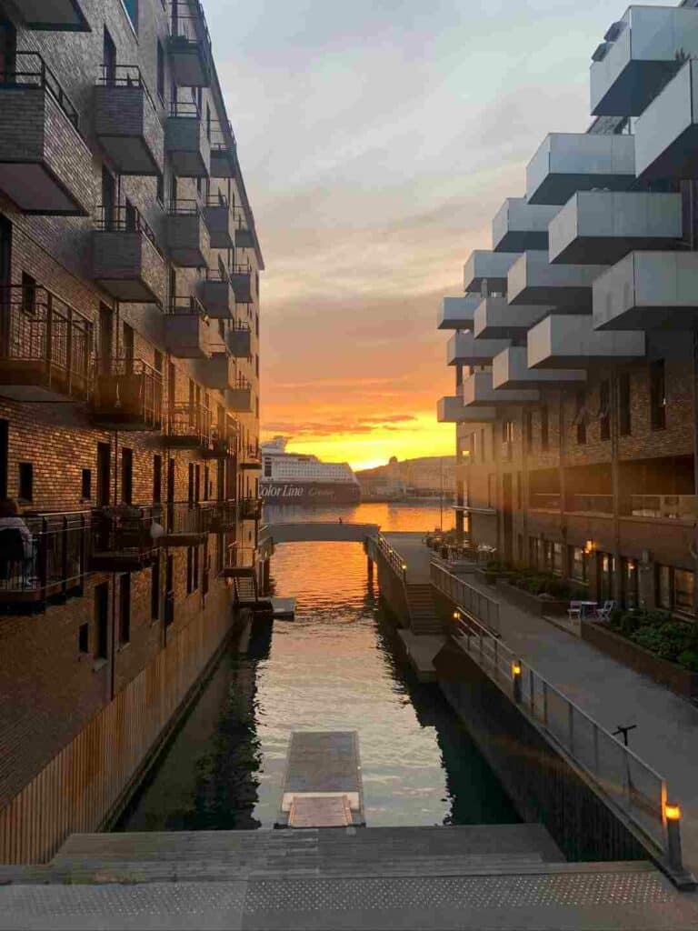 View of the sunset over the Oslo fjord seen through the new modern buildings of one of the artificial islands in Oslo