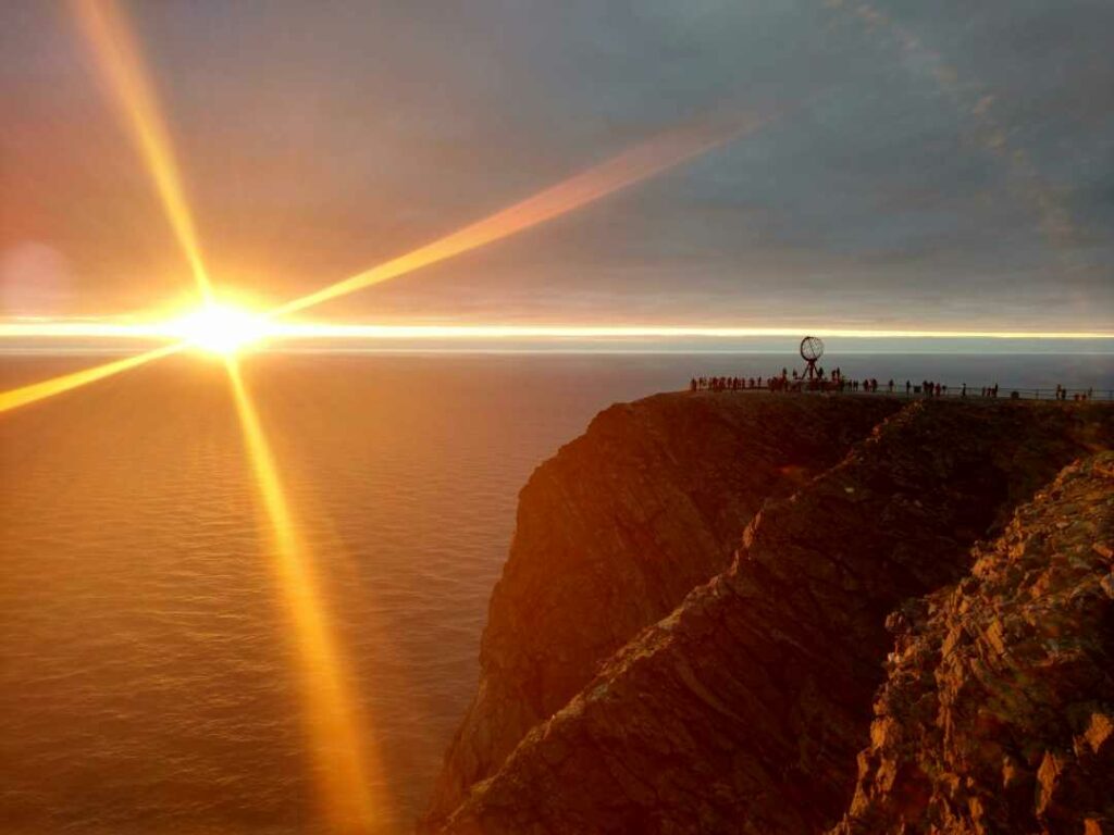 The majestic north cape plateau in Norway with the midnight sun golden right above the horizon