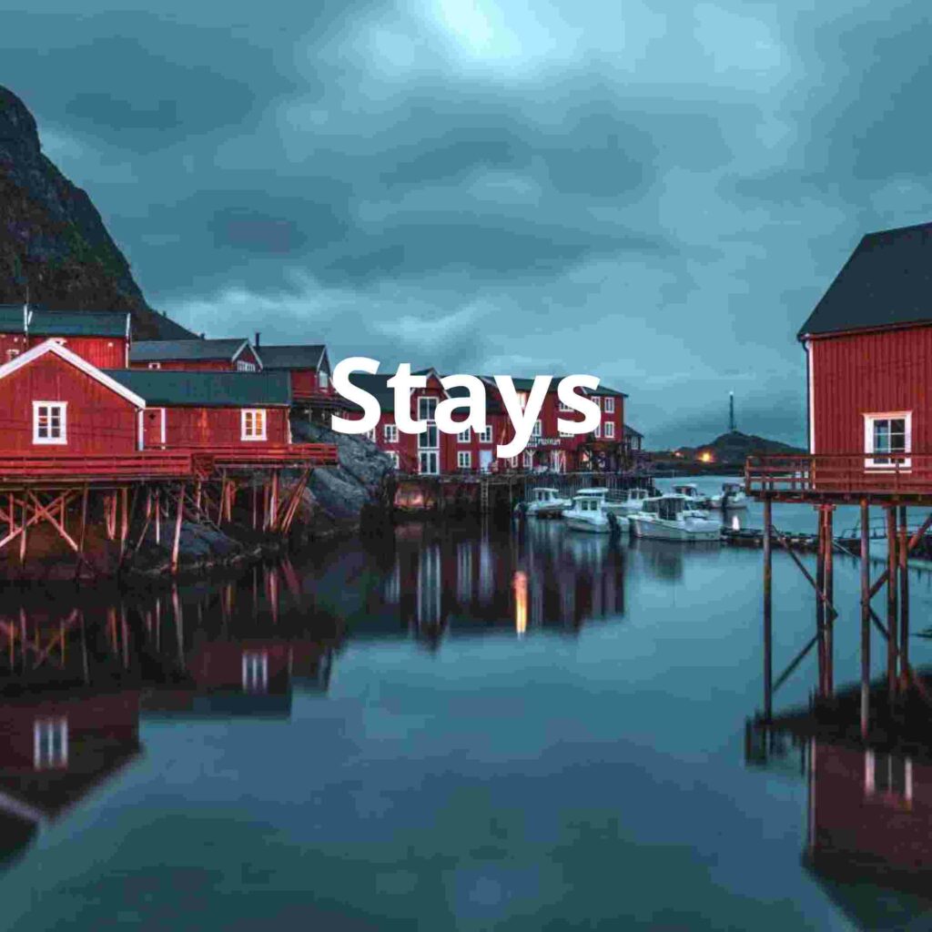 Red colored wooden rorbus, fishermans cottages, in Lofoten Norway in a blue silvery light in front of the majestic mountains
