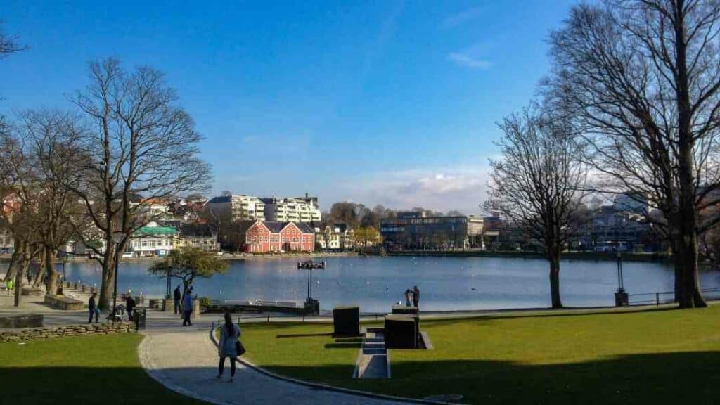 A sunny day in Stavanger center, with a quiet lake and a green park with large trees