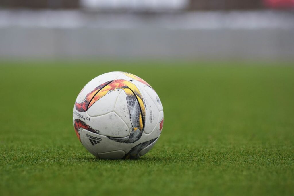 A white football on a green field