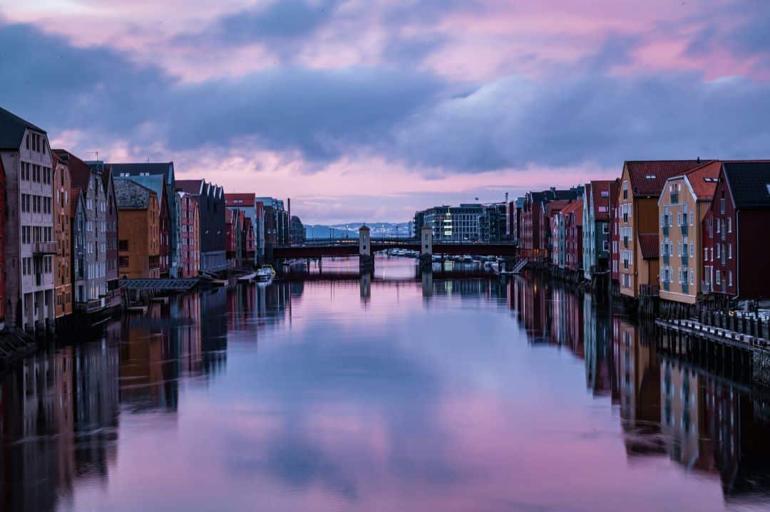 Sunset over water surrounded by old wooden colorful buildings in a glowing light