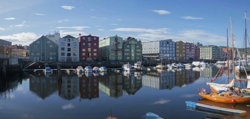 A small town harbor with dark blue water, lots of boats, and the colorful town along the wharf