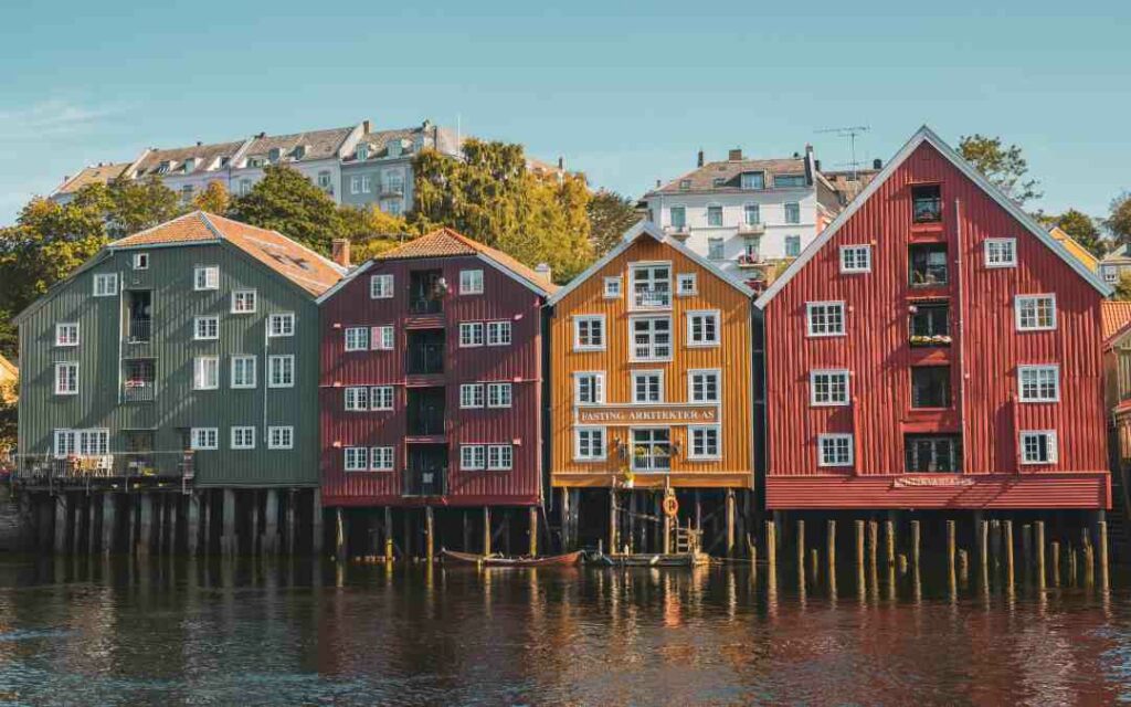 Colorful wooden houses with pointy roofs on a row by the river on a sunny summer day