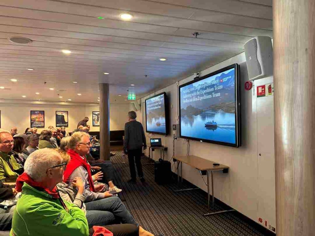 People seated in a conference room ready for a lecture about todays subject on a coastal cruise in Norway