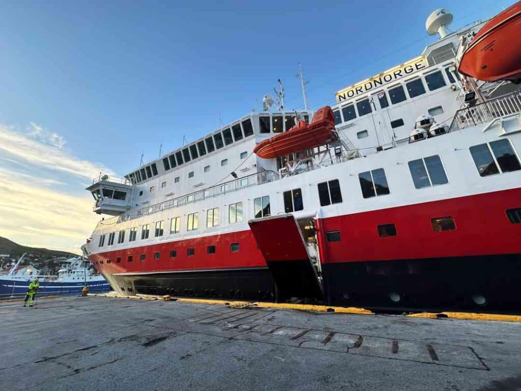 Red and white ship at port on a bright sunny day with blue skies, 