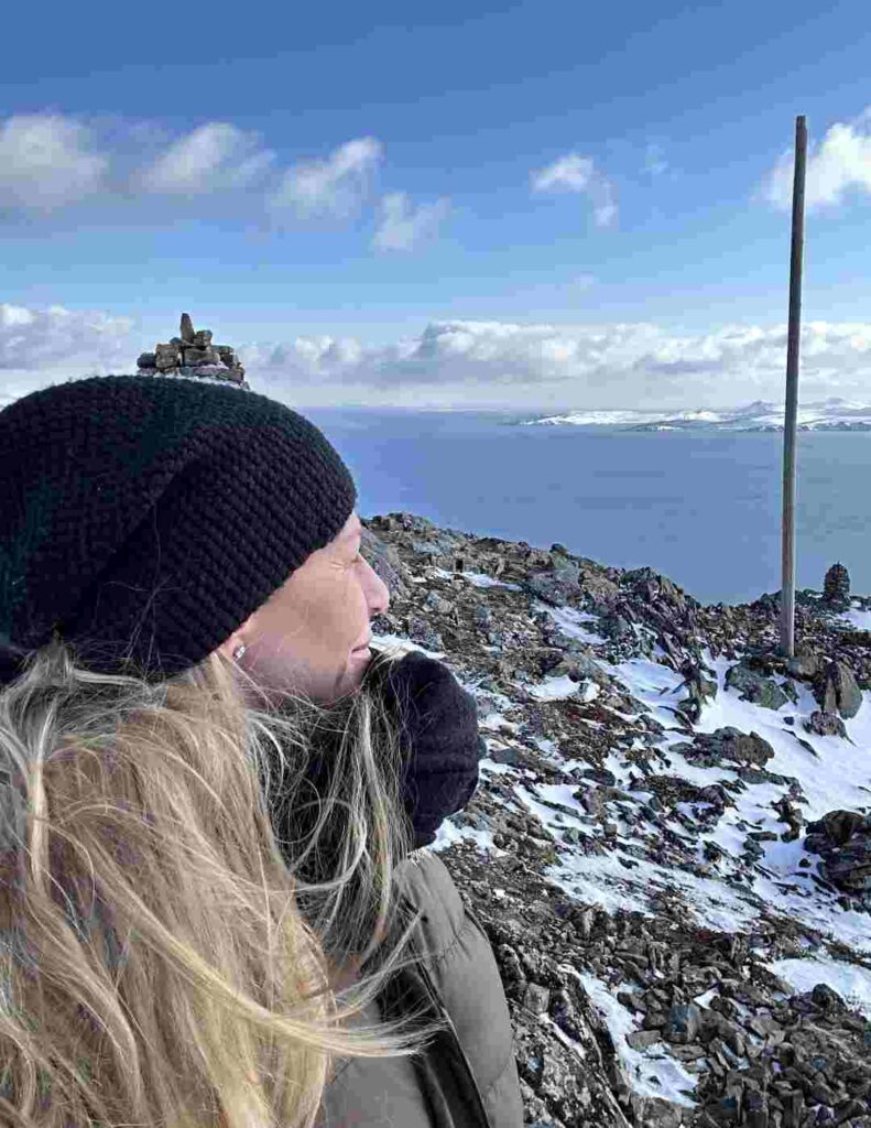 Woman standing on top of a mountain looking out at the view!