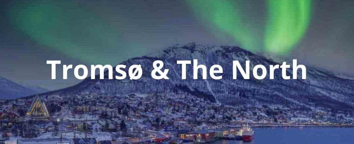 Tromsø with green dancing northern lights in the dark night sky over a snow capped mountain during the polar night