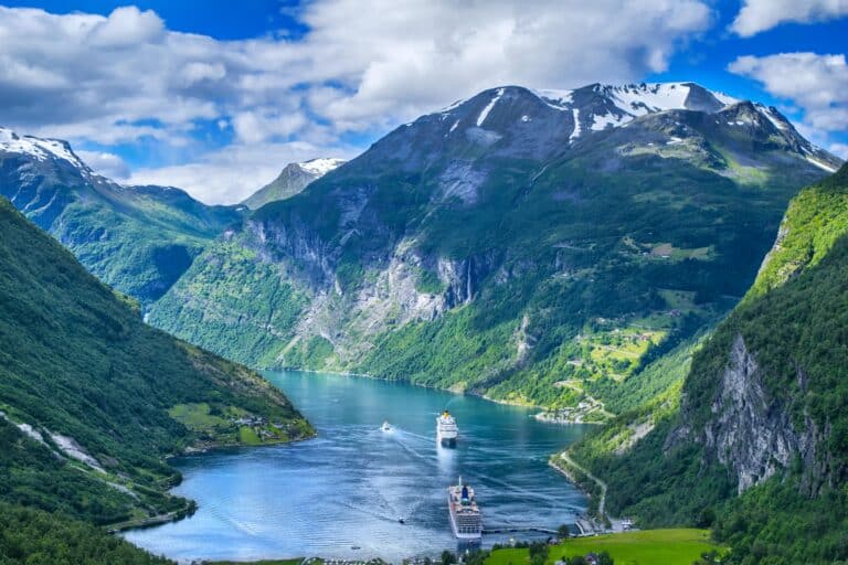 Two small ships in a deep fjord surrounded by steep mountains in the summer in Norway