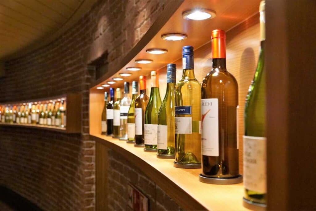 Bottles of wine on a shelf in a cosy environment with warm lighting