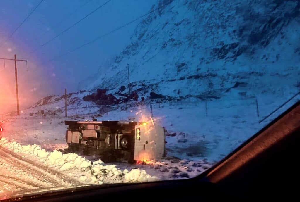 A car lying on its side on the side of the road in the dark winter in Lofoten, Norway